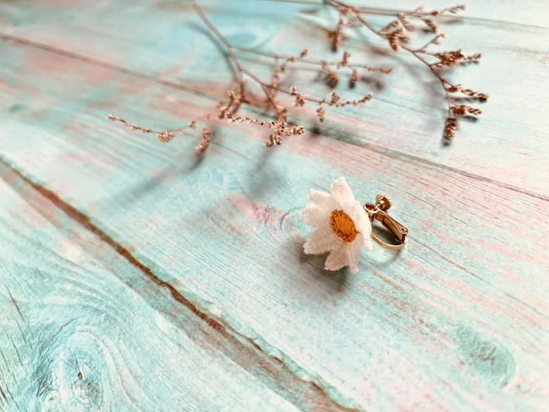 手刺繡耳夾。白晶菊