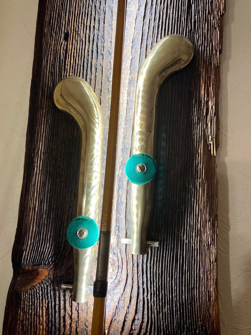 Wall sconce of antiques violin bow and brass pedals from the piano