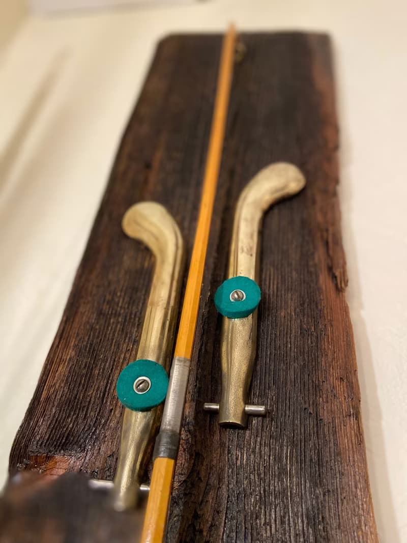 Wall sconce of antiques violin bow and brass pedals from the piano