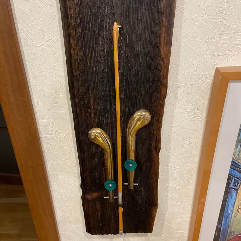 Wall sconce of antiques violin bow and brass pedals from the piano