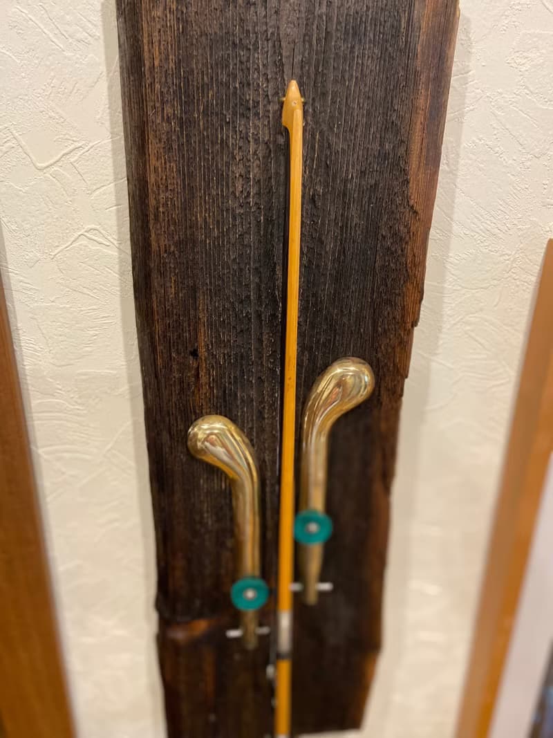 Wall sconce of antiques violin bow and brass pedals from the piano
