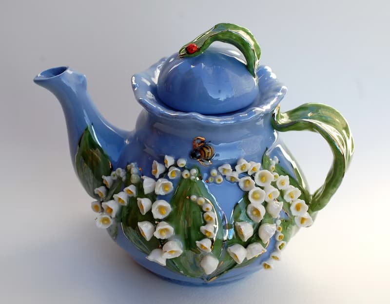 Beautiful blue teapot. Decor lilies of the valley and bees. Porcelain art.