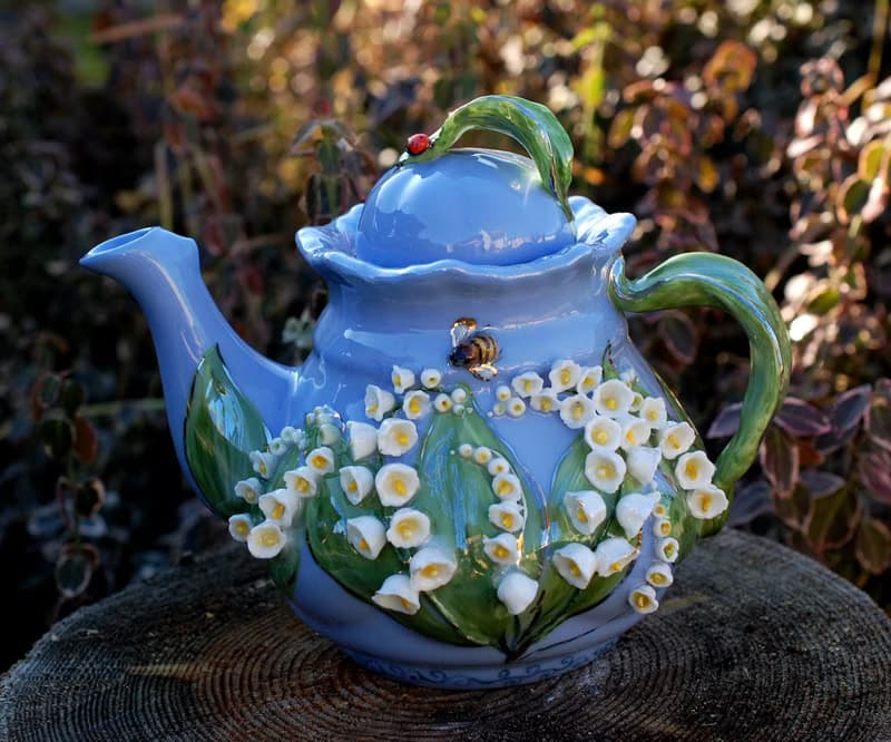 Beautiful blue teapot. Decor lilies of the valley and bees. Porcelain art.
