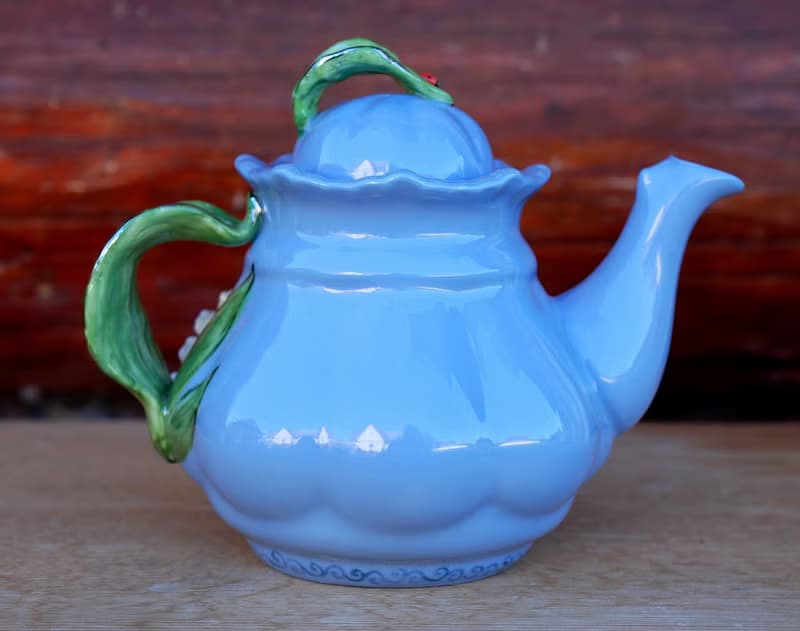 Beautiful blue teapot. Decor lilies of the valley and bees. Porcelain art.