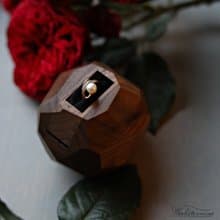 Wooden faceted sculptural ring display with black pillow, proposal ring box
