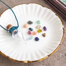 Glass bottle of gems for creativity boost, waxed cord, 12 raw crystals