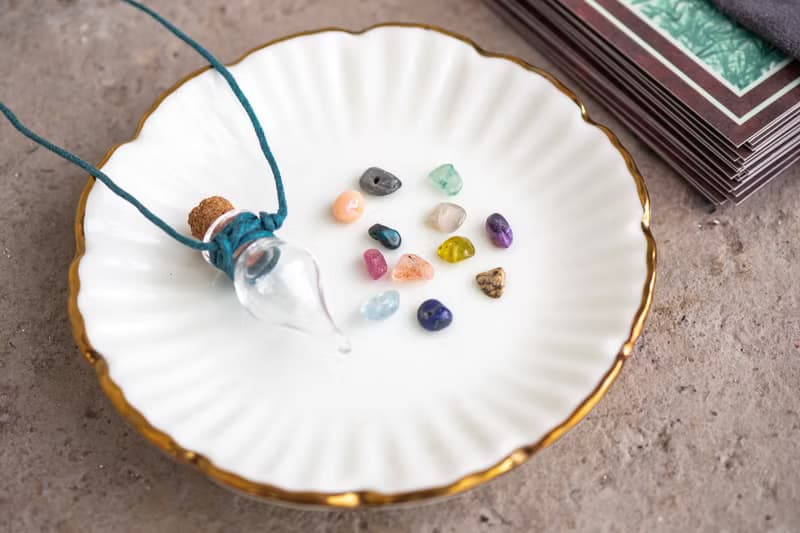 Glass bottle of gems for creativity boost, waxed cord, 12 raw crystals