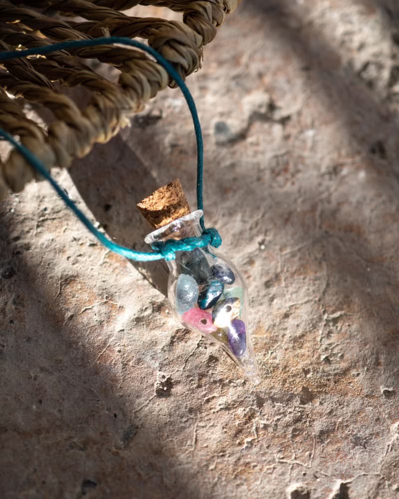 Glass bottle of gems for creativity boost, waxed cord, 12 raw crystals