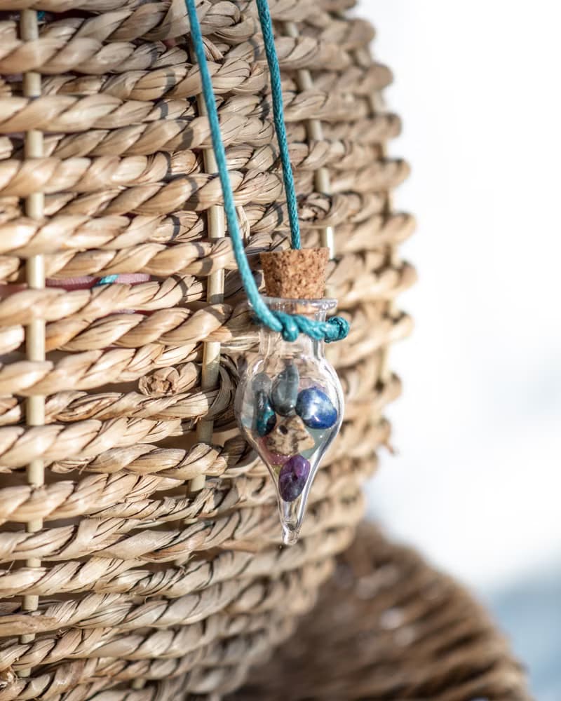 Glass bottle of gems for creativity boost, waxed cord, 12 raw crystals