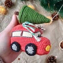 Red car with Christmas tree for gift. Holiday toy home decor. New year red car