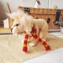 Soft toy lion in a scarf Gryffendor. Harry Potter symbol. Realistic lion figurin