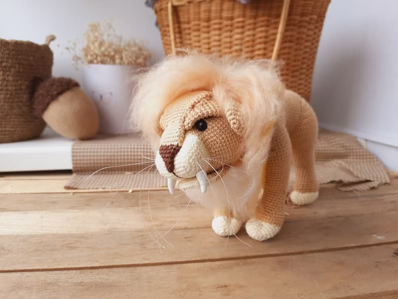 Soft toy lion in a scarf Gryffendor. Harry Potter symbol. Realistic lion figurin