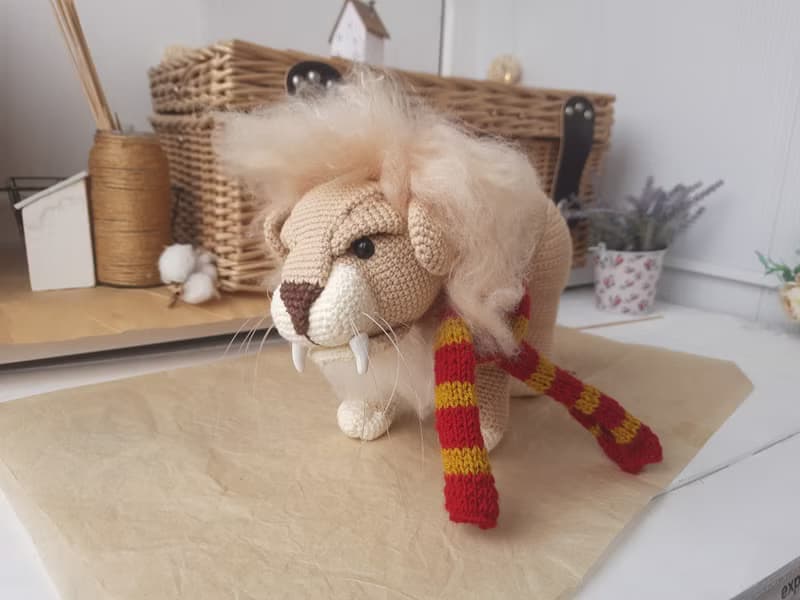 Soft toy lion in a scarf Gryffendor. Harry Potter symbol. Realistic lion figurin