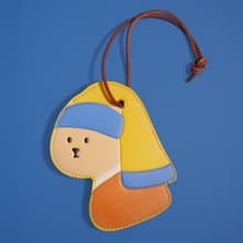 戴珍珠耳環的少女貓皮革行李牌