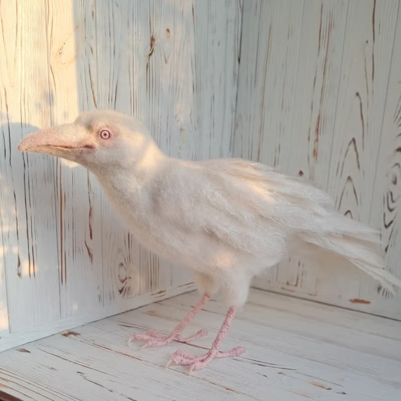 用羊毛氈製成的白色烏鴉雕塑。室內烏鴉家居裝飾