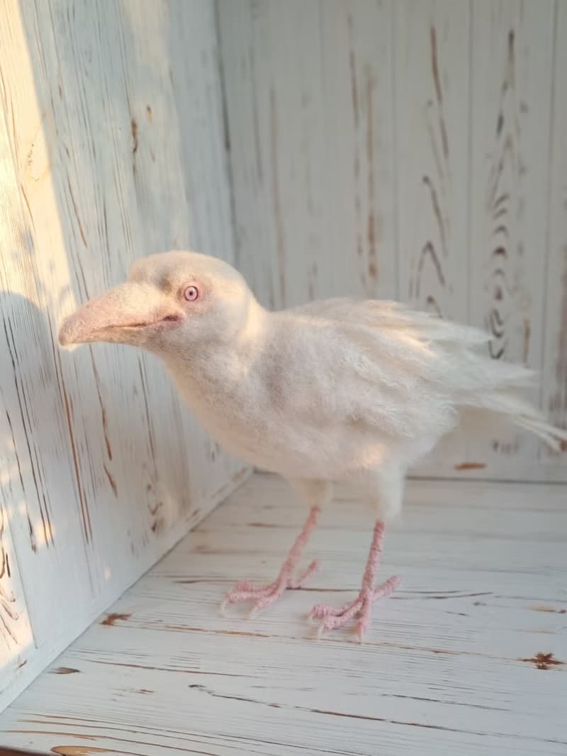 用羊毛氈製成的白色烏鴉雕塑。室內烏鴉家居裝飾