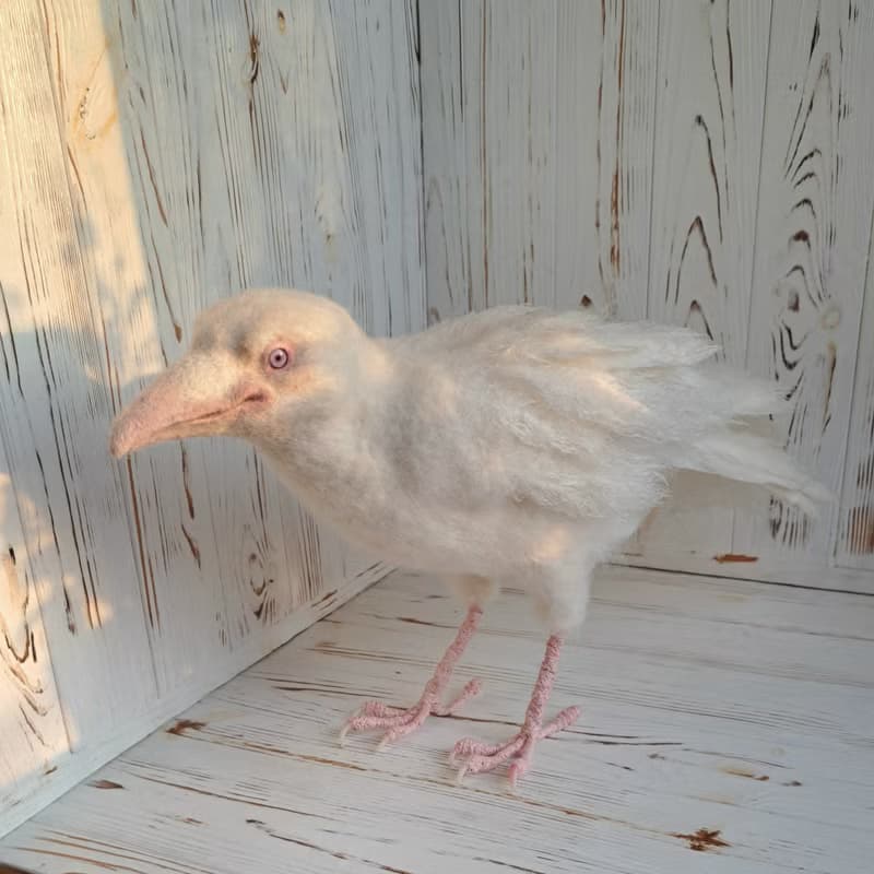 用羊毛氈製成的白色烏鴉雕塑。室內烏鴉家居裝飾