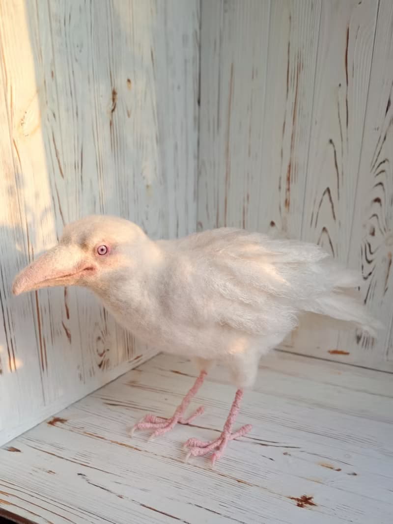 用羊毛氈製成的白色烏鴉雕塑。室內烏鴉家居裝飾