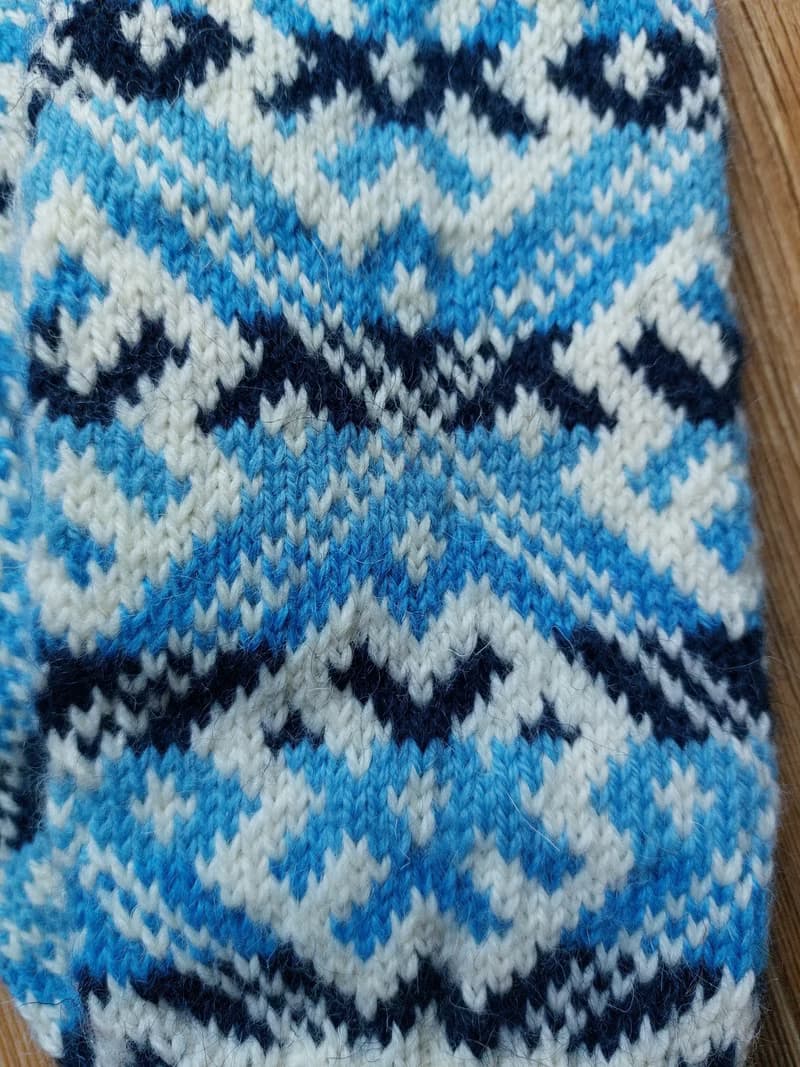 Women's and men's hand-knitted wool mittens are very warm with a pattern
