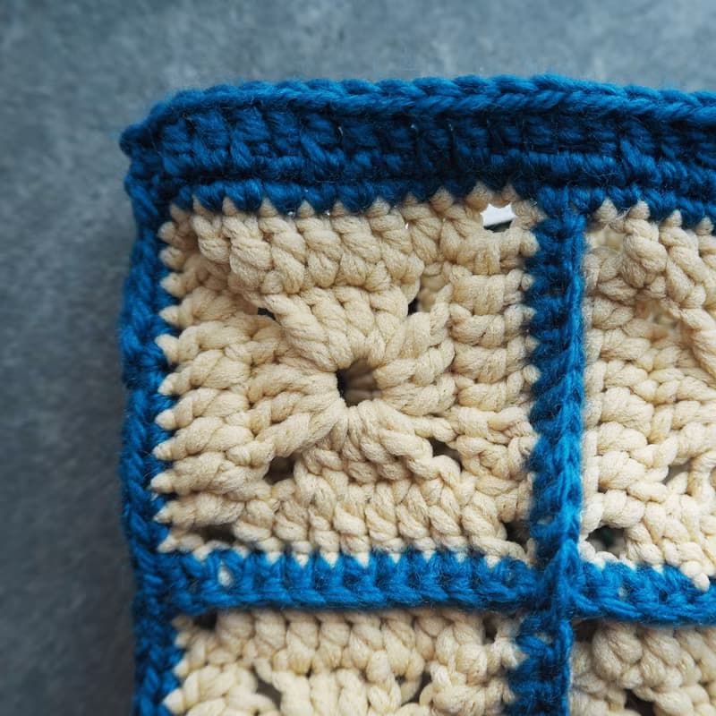 スクエアモチーフのフラットポーチ　ミニタッセル付き