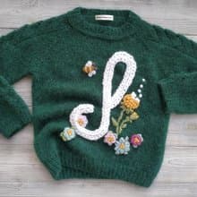 Handmade alpaca sweater with baby's name and embroidered flowers. Gift for girl.