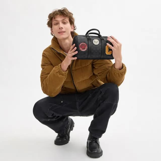 【COACH】蔻馳官方直營 VENTURER 27 經典 SIGNATURE 帆布與徽章旅行袋 旅行包 行李袋 斜背包-炭黑色(CY821)