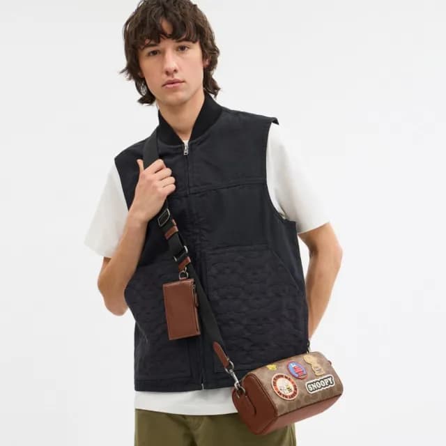【COACH】蔻馳官方直營 COACH X PEANUTS AXEL經典Logo貼飾斜背手袋-青銅色硬體/棕黃色 混合色(CBS96)
