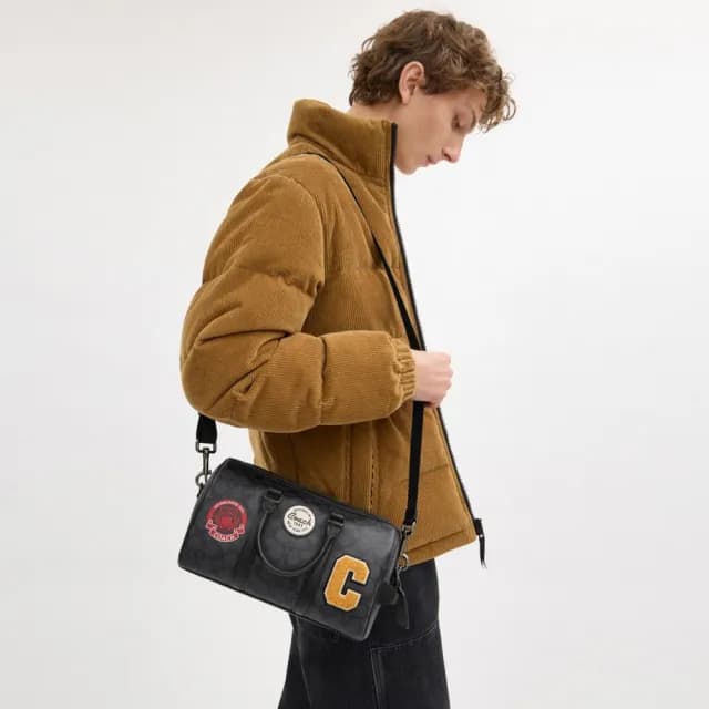 【COACH】蔻馳官方直營 VENTURER 27 經典 SIGNATURE 帆布與徽章旅行袋 旅行包 行李袋 斜背包-炭黑色(CY821)